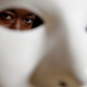 Massachusetts Institute of Technology facial recognition researcher Joy Buolamwini stands for a portrait behind a mask at the school, in Cambridge, Mass. Buolamwini’s research has uncovered racial and gender bias in facial analysis tools sold by companies such as Amazon that have a hard time recognizing certain faces, especially darker-skinned women.